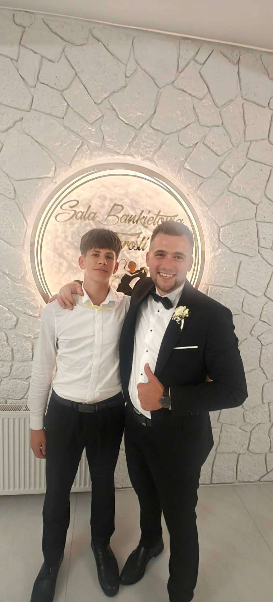 Sala w Turośli – pan młody w smokingu z gościem w hallu